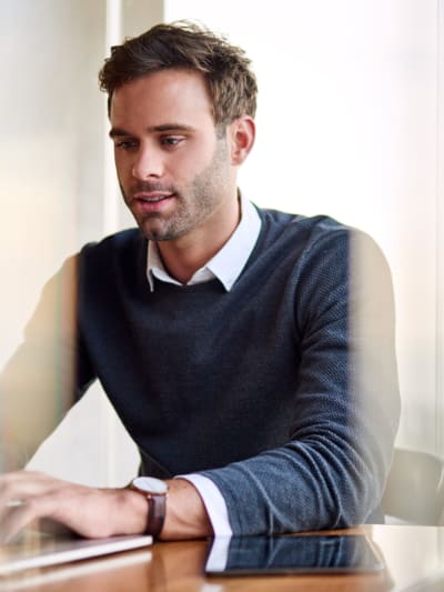 Person sits in conference room working on laptop.